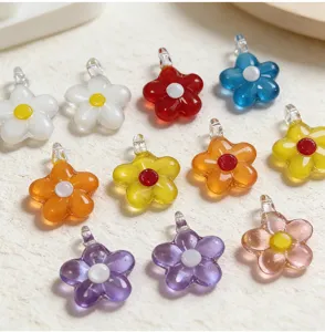 Detailed shot of colorful glass flower charms, mini five-petal pendant beads for DIY jewelry.