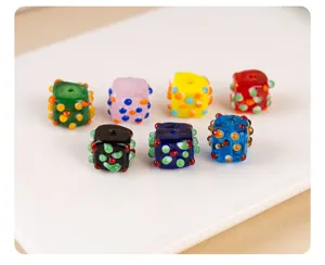 Close-up of colorful polka dot square glass beads for DIY handmade jewelry and necklace parts.