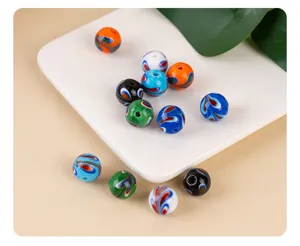 Detailed close-up view of colorful glass beads with swirl patterns for DIY jewelry making.