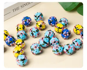 Close-up detail of colorful glass lampwork beads, floral pattern DIY jewelry making charms.