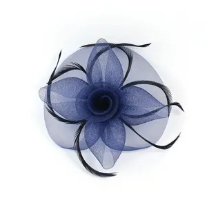 Gros plan détaillé de l'accessoire de cheveux fleur en résille bleu marine et plumes.