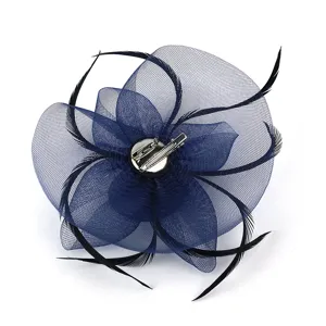 Détail de fascinateur en résille bleu foncé avec pince métallique et plumes noires.