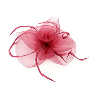 Détail fascinateur fleur en résille rouge, accessoire cheveux plume élégant pour mariage.