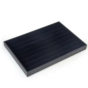 Black velvet jewelry display tray detail showing soft slot texture for rings and small earrings.