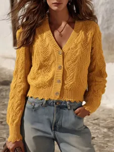 Closeup of the yellow cable-knit V-neck cardigan, showing delicate texture and buttons.