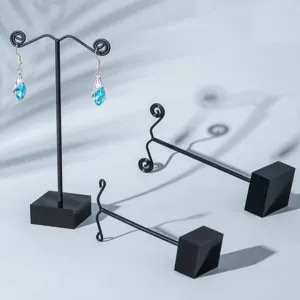 Vue détaillée de supports de présentation de boucles d'oreilles en métal noir avec cristaux.