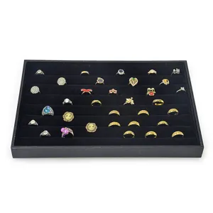 Black velvet jewelry display tray with multiple slots showcasing various rings for retail display.