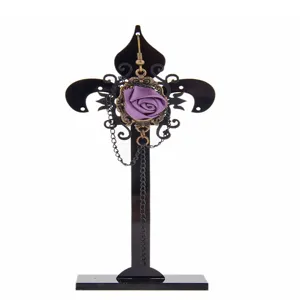 Detailed close-up of gothic black acrylic earring display stand with purple rose pendant.