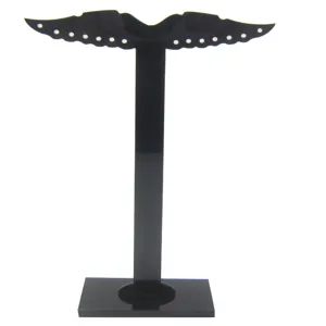 Detalle de soporte exhibición aretes acrílico negro, joyero en forma de T con múltiples agujeros.