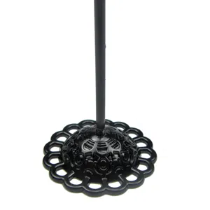 Close-up detail showing the exquisite black metal jewelry display stand with a clover shaped base.