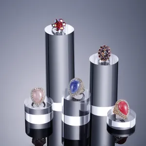 Présentoirs cylindriques en acrylique transparent pour bijoux et objets de collection.