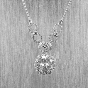 Dettaglio collana in strass argentati, elegante ciondolo con design floreale raffinato.