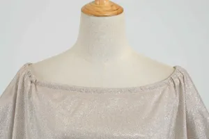 Nahaufnahme des glitzernden schulterfreien Kleids mit funkelndem Stoff und edlem Ausschnitt.