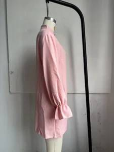 Side view detail of pink long sleeve dress, high neck and ruffled cuff design, simple style.