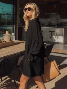 Detailed view of a stylish black long-sleeve loose shirt dress with pleated cuffs.