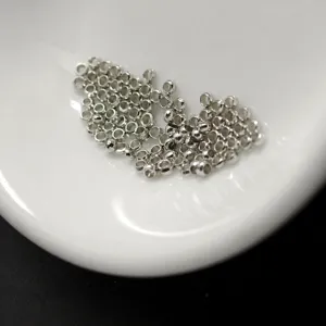 Silver metal spacer beads close up, large hole crimp beads for jewelry making DIY crafting detail view.