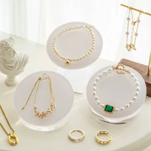 Detailed view of clear acrylic jewelry display stands showcasing elegant pearl bracelets and rings.