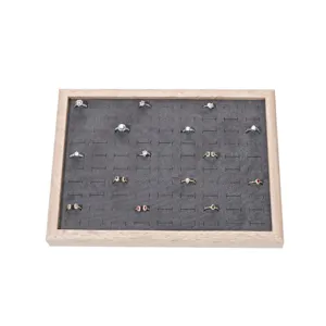 Wooden ring display tray featuring grey velvet insert slots for jewelry organization details.