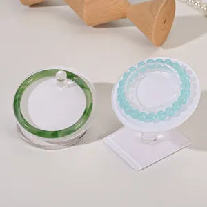 Acrylic jewelry display stand detail shot showing transparent tray with bangle and bracelet.