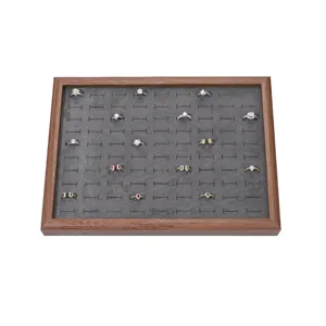 Wooden ring display tray featuring grey velvet insert and multi-slot jewelry storage for retail.