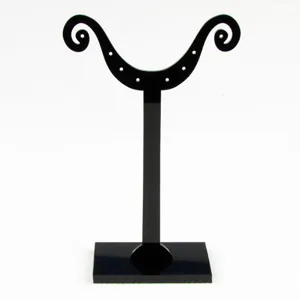Détail de présentoir de boucles d'oreilles en acrylique noir avec des trous pour bijoux.