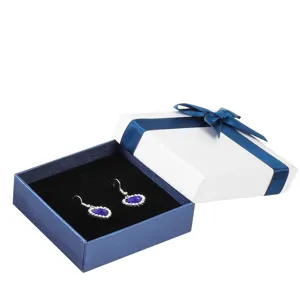 Elegant blue and white gift box with ribbon and heart earrings for jewelry packaging.