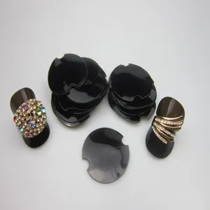Supports de présentation de bagues en plastique noir et tampons de rangement pour vitrines.