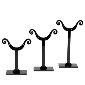 Lot de trois présentoirs à boucles d'oreilles en acrylique noir de hauteurs différentes.