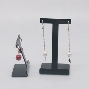 Gros plan détaillé de supports de présentation de boucles d'oreilles en acrylique noir.
