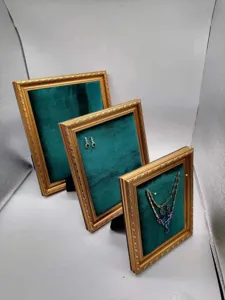 Detailed view of vintage dark green velvet photo frame jewelry display stand sets.