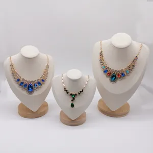 Detail shot of microfiber jewelry display busts showcasing crystal necklaces in a clean studio.
