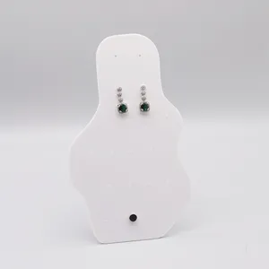 Élégantes boucles d'oreilles argentées avec des pierres scintillantes et une gemme verte centrale.