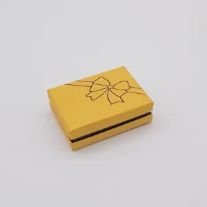 Yellow paper jewelry gift box with bow design, elegant packaging for rings and necklaces.