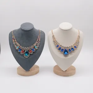 Detailed view of microfiber neck jewelry display stands with crystal gemstone statement necklaces.