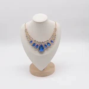 Detail of gold necklace with vivid blue teardrop crystals and sparkling clear rhinestones.