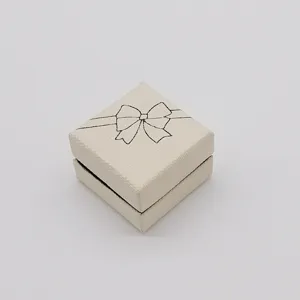 White textured jewelry gift box detail with black bow graphic for rings and necklaces packing.