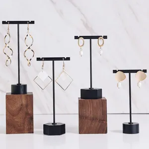Gros plan de supports à bijoux en métal minimaliste présentant de superbes boucles d'oreilles.