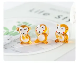 Handmade glass monkey figurine detail, cute desktop animal ornament with amber and white finish.