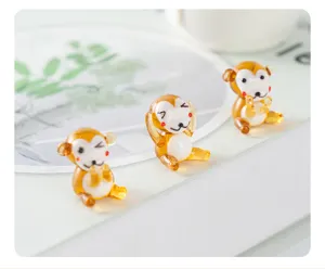 Close-up detail of handmade glass monkey miniature ornament, cute amber animal desktop decor.