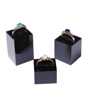 Detailed view of black acrylic ring display stands showcasing decorative gemstone rings.