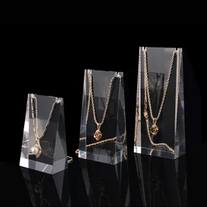 Detailed view of clear acrylic necklace display stands showcasing elegant gold pendant jewelry.