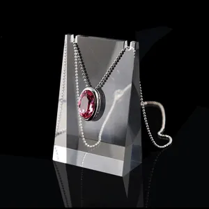 Silver beaded chain necklace featuring an oval red crystal pendant on clear acrylic stand.