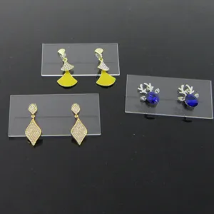 Vue détaillée de plusieurs boucles d'oreilles tendance sur des supports en acrylique.