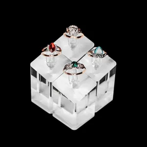 Close-up detail of luxury rose gold rings with colorful gems and love design on clear stands.