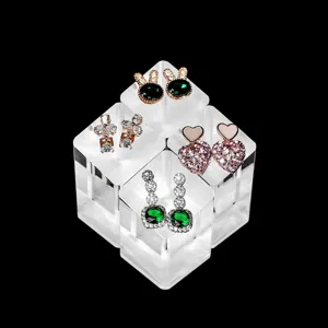 Clear acrylic cube display stand with multi-pair fashion earrings showcase detail.
