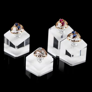 Gold ring set with double oval stones displayed on clear acrylic stands for jewelry showcase.