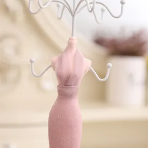 Detailed view of creative pink dress jewelry display stand for necklaces and earrings.