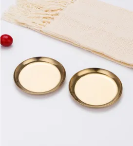 Gros plan détail d'un plateau de présentation de bijoux rond en or moderne et minimaliste.
