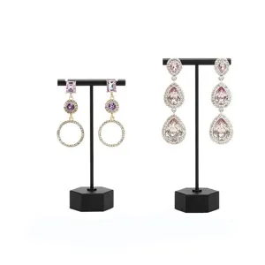 Vue détaillée de boucles d'oreilles en cristal et strass violettes sur supports en T noirs.