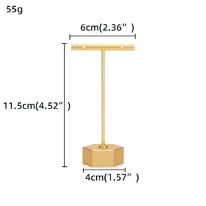 Détail de support de bijoux en métal doré en forme de T, base hexagonale stable.
